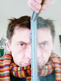 Close-up portrait of man holding window