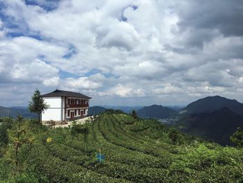 Built structure on landscape against clouds