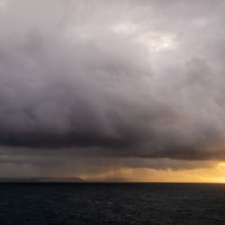 Scenic view of sea against storm clouds