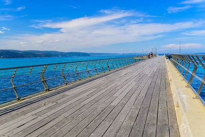 Pier over sea against blue sky