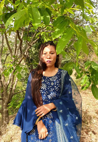 Beautiful young woman standing against plants