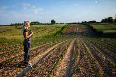 Rear view of woman standing on field