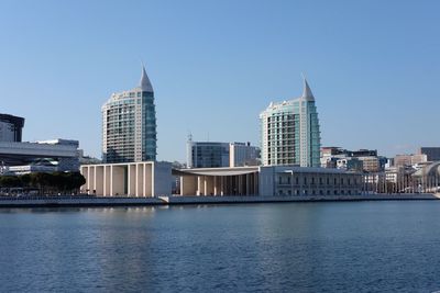 Modern buildings in city against clear blue sky