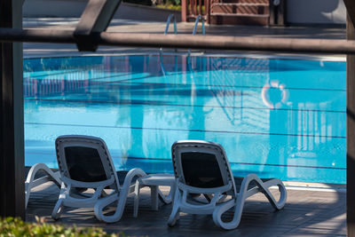 Empty chairs in swimming pool