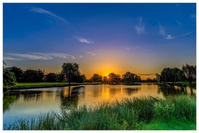 Scenic view of lake against sky at sunset