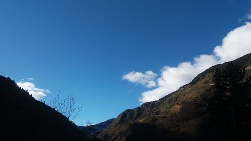 Low angle view of mountains against blue sky