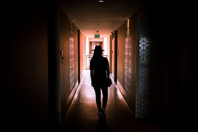 Rear view of silhouette man walking in corridor
