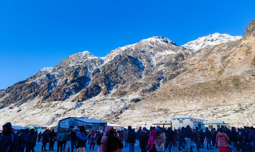 People on mountain against clear blue sky kedarnath temple