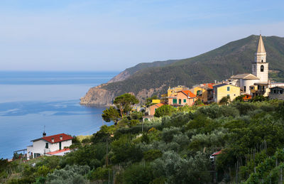 Buildings by sea against sky