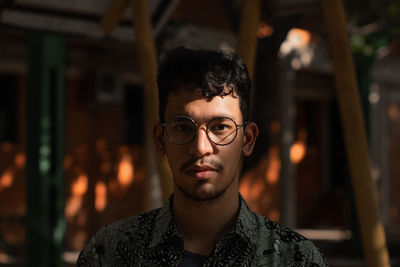 Mixed race man wears round eyeglasses under the shades and sunlight