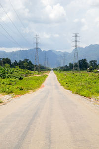 Road amidst green landscape against sky