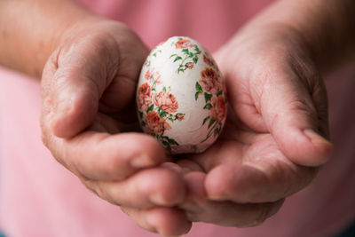 Midsection of woman holding ester egg in hand