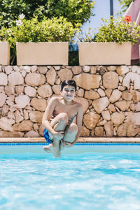 Little child jumping into a pool