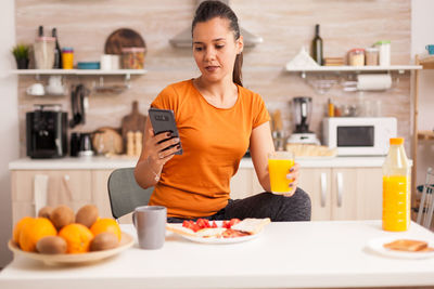 Young woman using smart phone at home