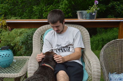 Portrait of young woman sitting on chair at home