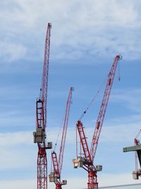 Cranes at construction site against sky