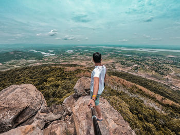 Rear view of man looking at sea against sky