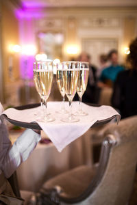 The waiter spends glasses with champagne in a restaurant