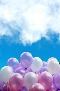 Low angle view of balloons against cloudy sky