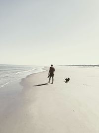 Man on beach against clear sky