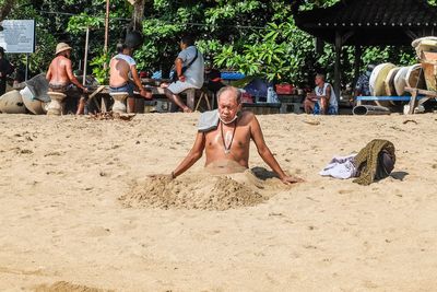 Group of people sitting on sand