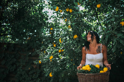 Full length of young woman against tree