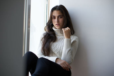 Portrait of young woman standing at home