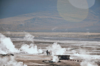 Hot spring on landscape against sky