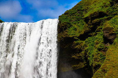 Scenic view of waterfall against sky