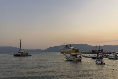 Sailboats on sea against sky during sunset