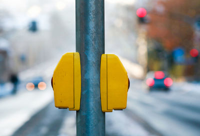 Close-up of yellow pole on road in city