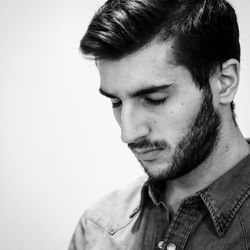 Close-up of young man with eyes closed against white background