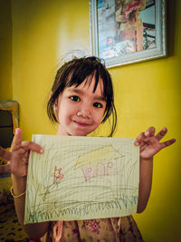 Portrait of cute girl holding paper