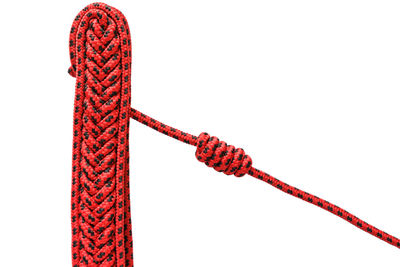 Close-up of rope tied on metal against white background