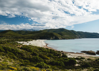 Scenic view of sea and mountains against sky