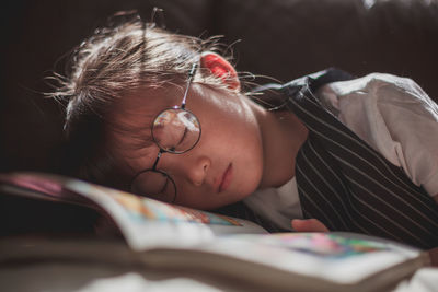 Close-up portrait of boy lying on bed at home
