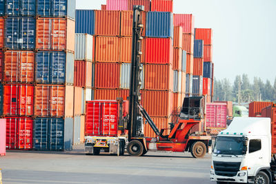 Container forklift moving containers into trucks