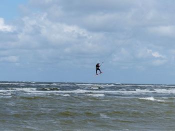 Man surfing in sea against sky