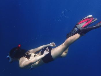 Full length of young woman snorkeling in sea