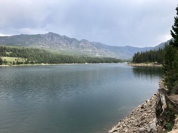 Scenic view of lake by mountains against sky