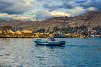 Man on boat in sea against sky