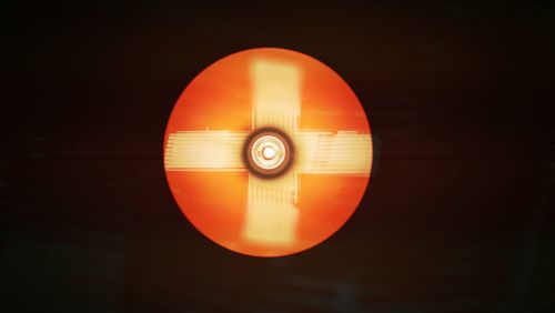 Close-up of illuminated lamp against sky at night