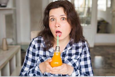 Portrait of young woman drinking drink