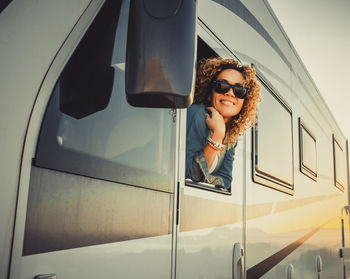 Portrait of young woman leaning outside van