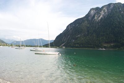 Sailboats in sea against sky