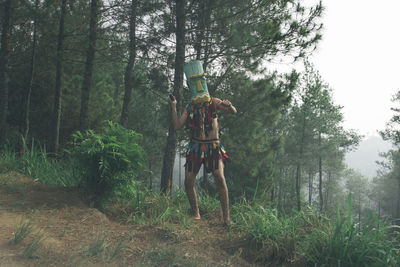 Man standing by plants in forest