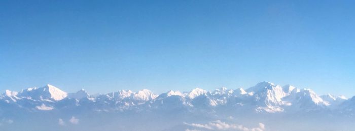 Low angle view of snowcapped mountain against blue sky