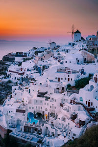 High angle view of townscape by sea against sky during sunset