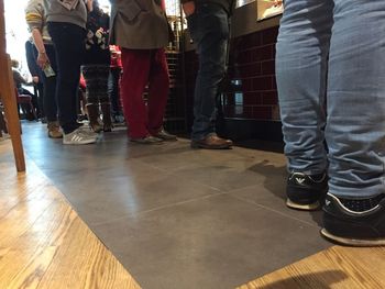 Low section of people standing on hardwood floor