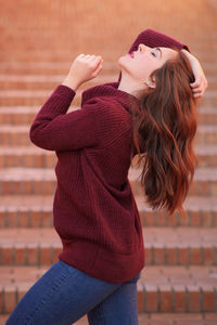 Midsection of woman wearing hat standing outdoors